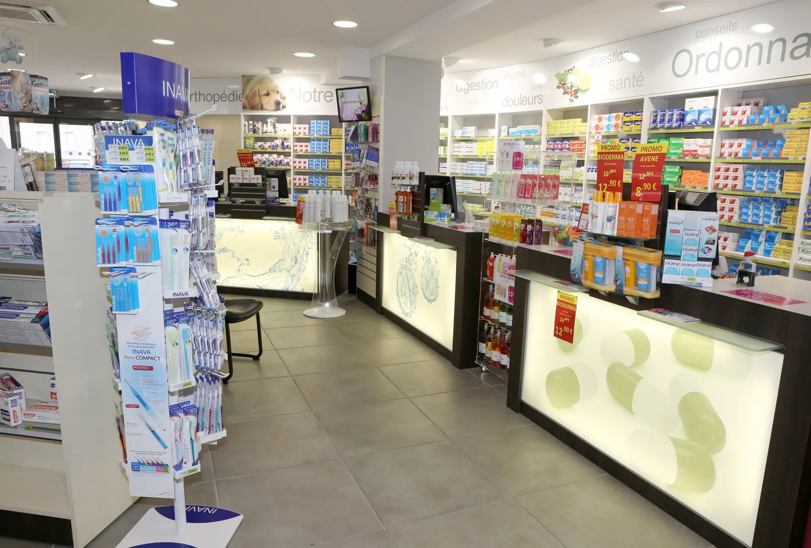 Intérieur de pharmacie agencé par Diagonale : comptoirs rétroéclairés et linéaires de parapharmacie